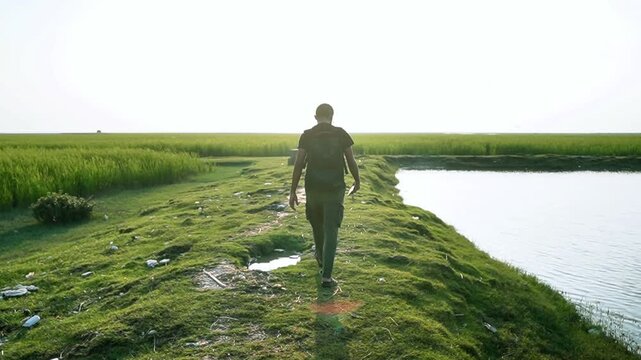 young man walking in the green feild