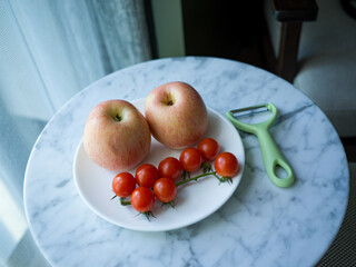 apples and tomatoes on the plate on the table