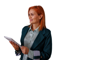 Businesswoman with red hair holding tablet, smiling and looking away, standing confidently on transparent background