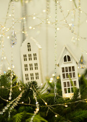 Wooden decorative houses with Christmas lights and fir branches