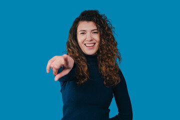 female hostess advert, presenter gestures amidst vibrant blue backdrop effectively engaging