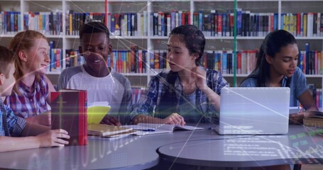 Collaborating students researching data at media center table, with red tablet and yellow notebook