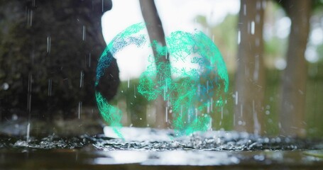 Hovering holographic green wireframe sphere above wet forest floor puddle, with falling raindrops