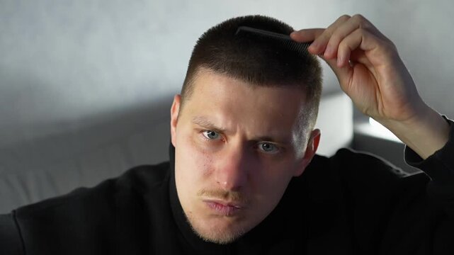 A guy with scalp problems.
A man combs his short hair with a comb.
A close-up of a man's blond hair.