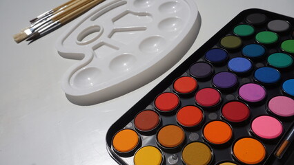 Palette of watercolors and brushes on a white background