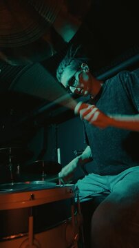 Vividly lit drum solo showcasing dynamic stick techniques