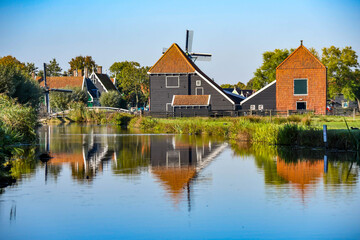 Obraz premium Picturesque scene of classic Dutch architecture and a canal with clear reflections on a sunny day