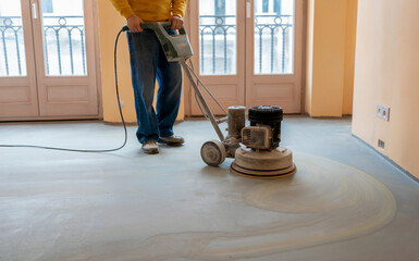 Fototapeta premium Worker Renovating with a Concrete Floor Grinding Machine