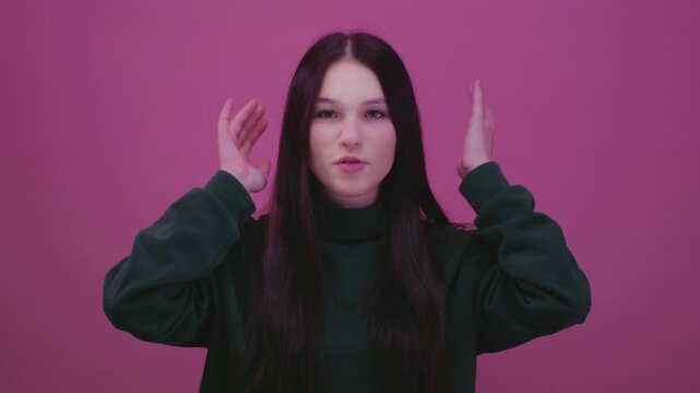 Teen girl making a mind blown gesture near her head, expressing amazement or disbelief. Beautiful female, generation Z or alpha twists and shakes her hands at her head, a crazy gesture.