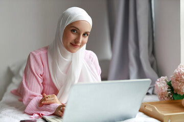 Muslim businesswoman working on laptop	
