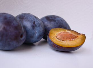 fresh plums arranged in a group, halved plum