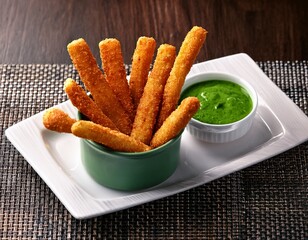 crispy fried food sticks with green sauce