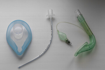 On the table is an endotracheal tube, oxygen and laryngeal masks. On a gray background.