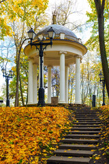 An ancient rotunda, staircase, and lantern in a city park in autumn