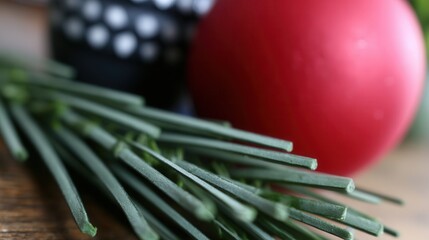 Close-up view of red ornament resting on a pine branch with green needles capturing holiday spirit and festive decor
