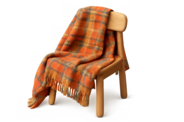 Orange wool plaid throw blanket draping over rustic wooden chair, creating cozy homely comfort with fall autumn vibes