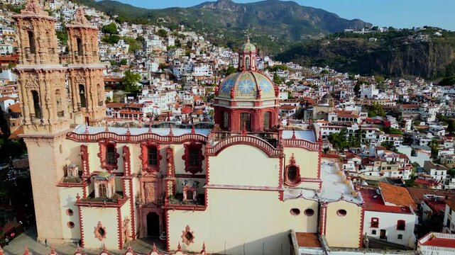 Circular aerial motion around Santa Prisca showing detailed facade and town of Taxco, Guerrero, Mexico