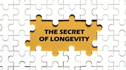 Fototapeta premium The concept of the words THE SECRET OF LONGEVITY in the middle of the puzzle. Yellow background.