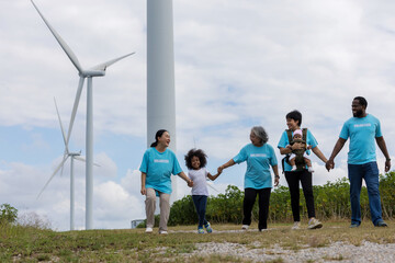 Family with daughter walking on field on wind farm. Happy Family and daughter playing at the Wind turbines generating electricity. Family time together.