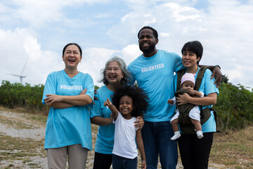 Family with daughter walking on field on wind farm. Happy Family and daughter playing at the Wind turbines generating electricity. Family time together.