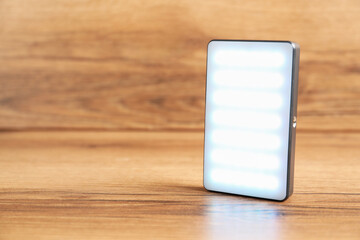 LED lamp on wooden background, closeup. Space for text
