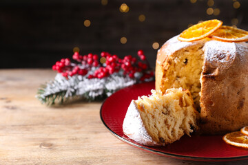 Christmas food. Delicious Panettone cake and festive decor on wooden table against background with blurred lights, closeup. Space for text