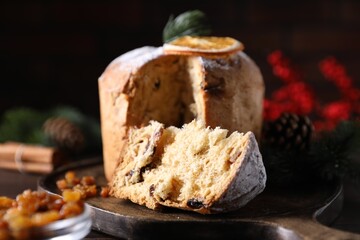 Christmas food. Delicious Panettone cake and festive decor on wooden table, closeup