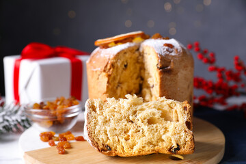 Christmas food. Delicious Panettone cake and festive decor on white table against background with blurred lights, closeup