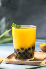 Mango smoothie with boba pearls, creamy mango lassi bubble tea, tropical summer drink