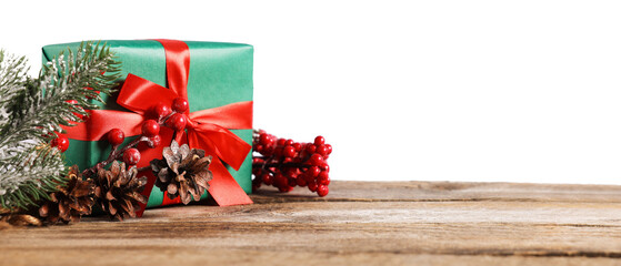 Fir tree branches, gift box and other Christmas decor on wooden table against light grey...