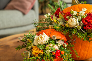 Close-up of pumpkin floral decor with roses and berries
