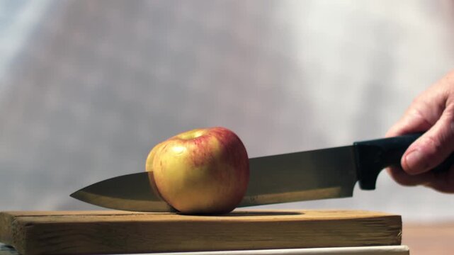 Chopping apple half with sharp knife