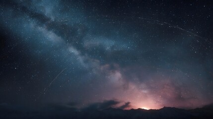 Fototapeta premium A breathtaking view of the Milky Way galaxy stretching across a starry night sky above silhouetted mountains with a subtle glow on the horizon