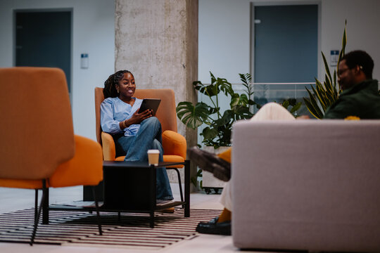 Coworkers discussing business and collaborating in office lounge
