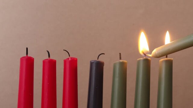 African American Kwanzaa holiday concept with traditional lit candles. Seven candles red, black and green