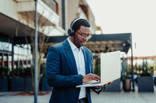 African american man working remotely with laptop and headphones