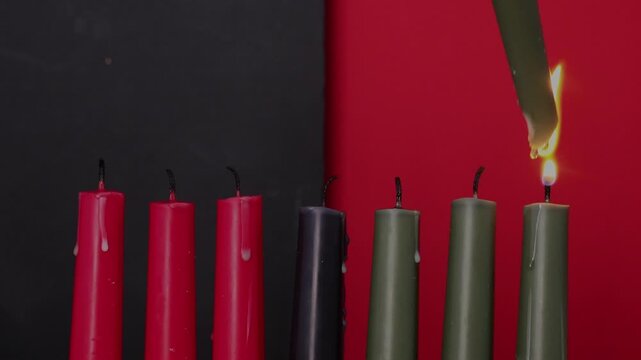 African American Kwanzaa holiday concept with traditional lit candles. Seven candles red, black and green