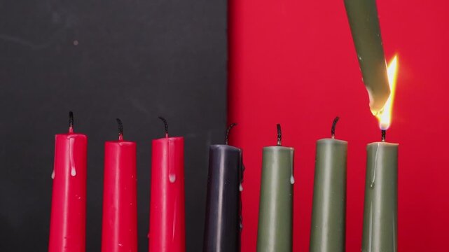 African American Kwanzaa holiday concept with traditional lit candles. Seven candles red, black and green