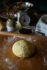 Ball of yeast dough spiced with saffron on wooden board.