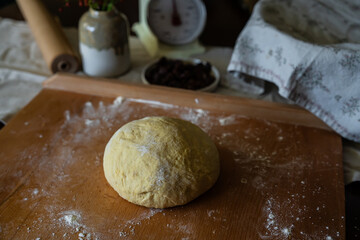 Process of making traditional Swedish saffron buns. Ball of yeast dough spiced with saffron on wooden board.