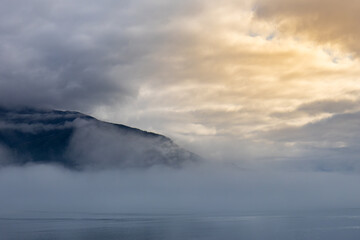 sun breaking through the clouds and fog in the inside passage
