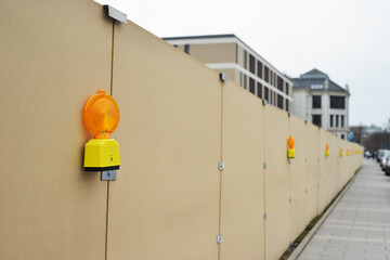 Construction site with warning lamp and wooden secure fence