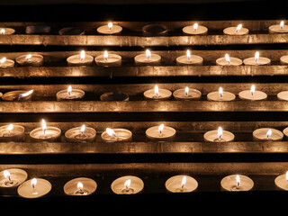 Rows of lit votive candles in the church