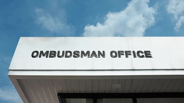 An Ombudsman Office word sign displayed on a civic or government building under a clear blue sky, symbolizing public oversight, consumer advocacy, fairness, and official review