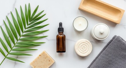 Still life of spa items including oil bottle and palm leaf on marble