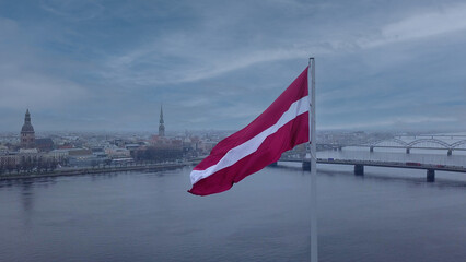 Drone View Of Riga Old Town With Latvian Flag Waving In Foreground Aerial Panorama Of Historic City Center, Daugava River And Urban Skyline On A Outumn Day In Latvia