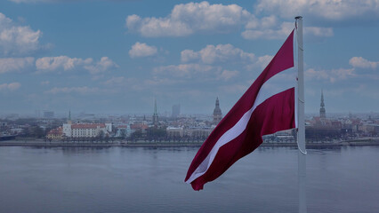 Drone View Of Riga Old Town With Latvian Flag Waving In Foreground Aerial Panorama Of Historic City Center, Daugava River And Urban Skyline On A Outumn Day In Latvia
