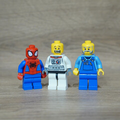 Naklejka premium Lego minifigures of Spider-Man, an astronaut, and a farmer standing together