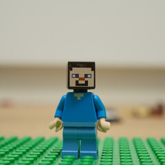 Naklejka premium Minecraft Steve Lego figure standing on a green baseplate