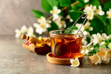 Fototapete Rund Tee Cup of jasmine tea and fresh jasmine flowers on a stone table.  © Igor Normann